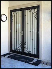 Puerta de acceso a portal realizada en forja y cristal
